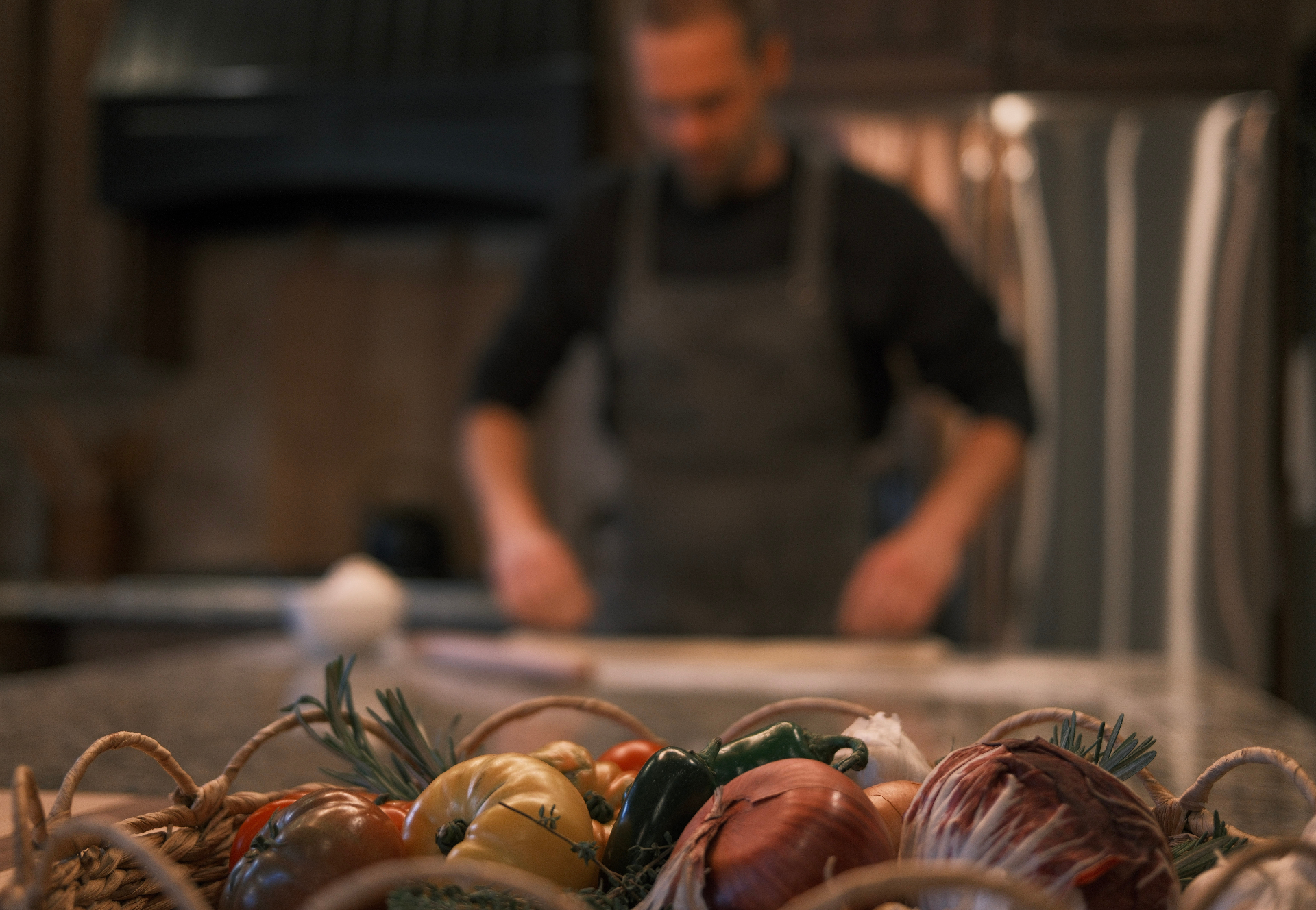 Fresh herbs, sourdough loaves and scratch ingredients on a rustic wooden table