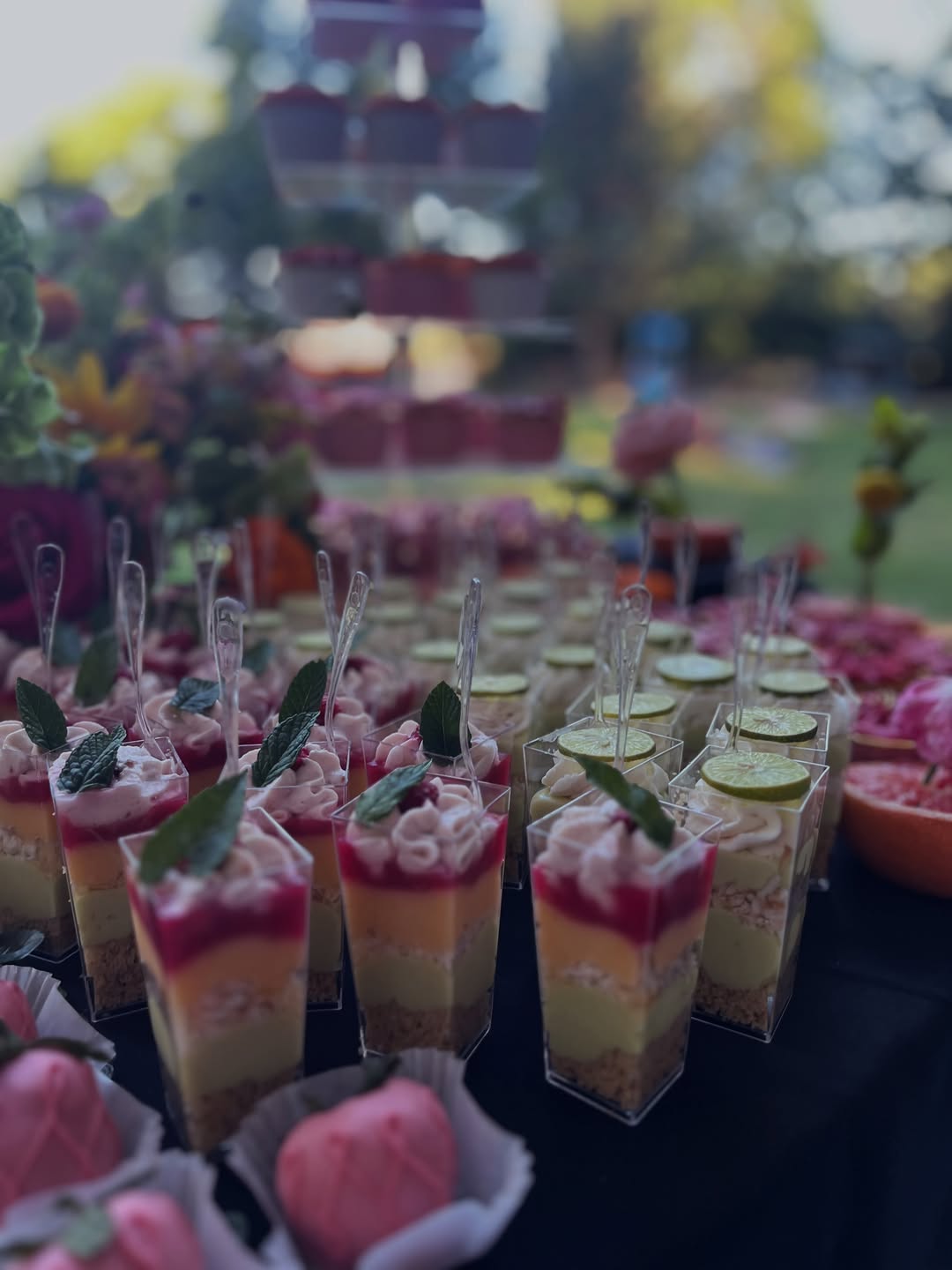 Individual layered dessert cups garnished with mint and lime